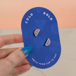 a hand holding a geometric card showing a pair of marble pastel purple half moon earring stud set