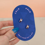 hand holding bright blue cold gold card displaying amethyst gold hoop earrings