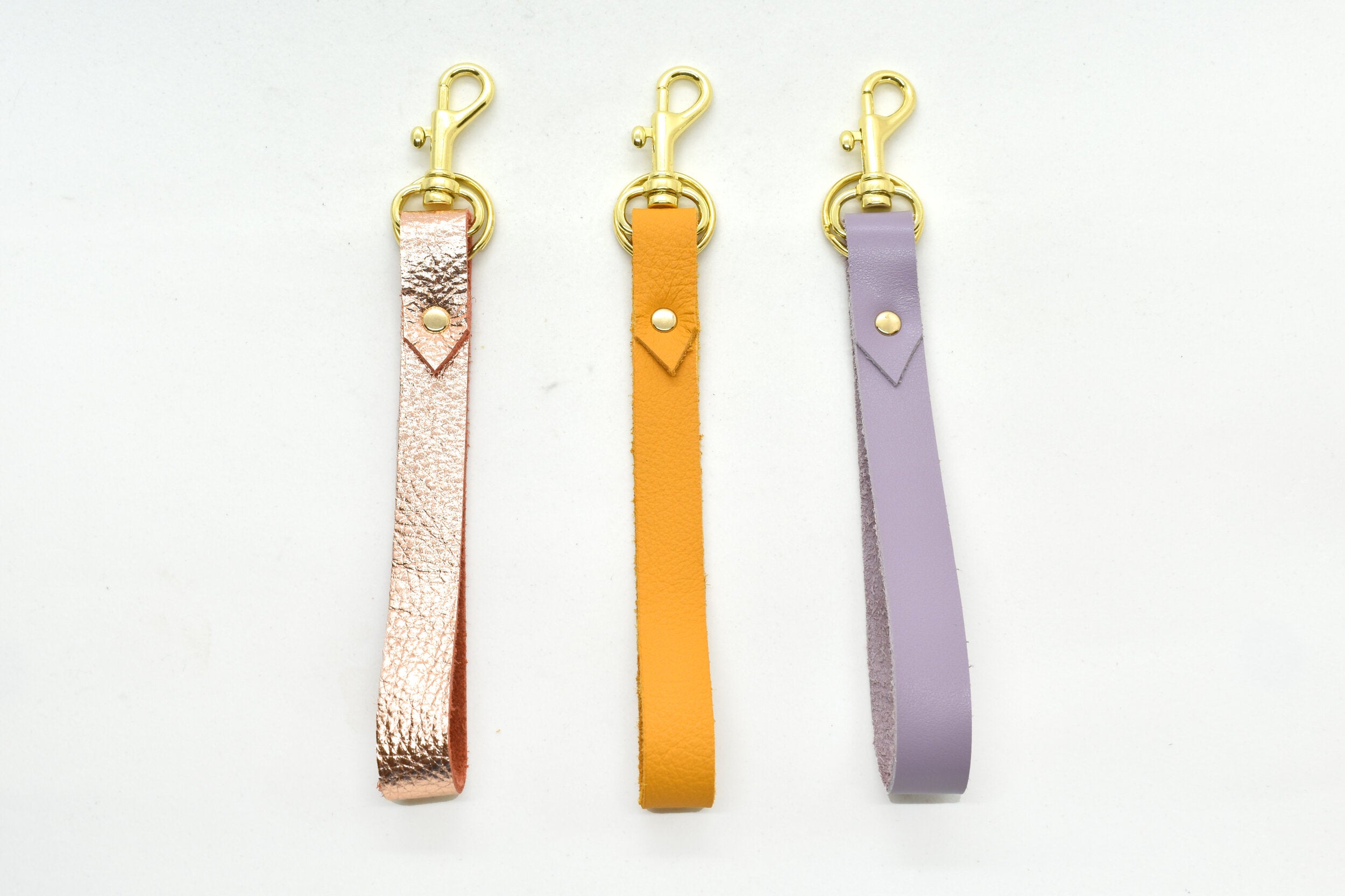 leather loop minimal and modern key chains in marigold lavender and metallic rose leather