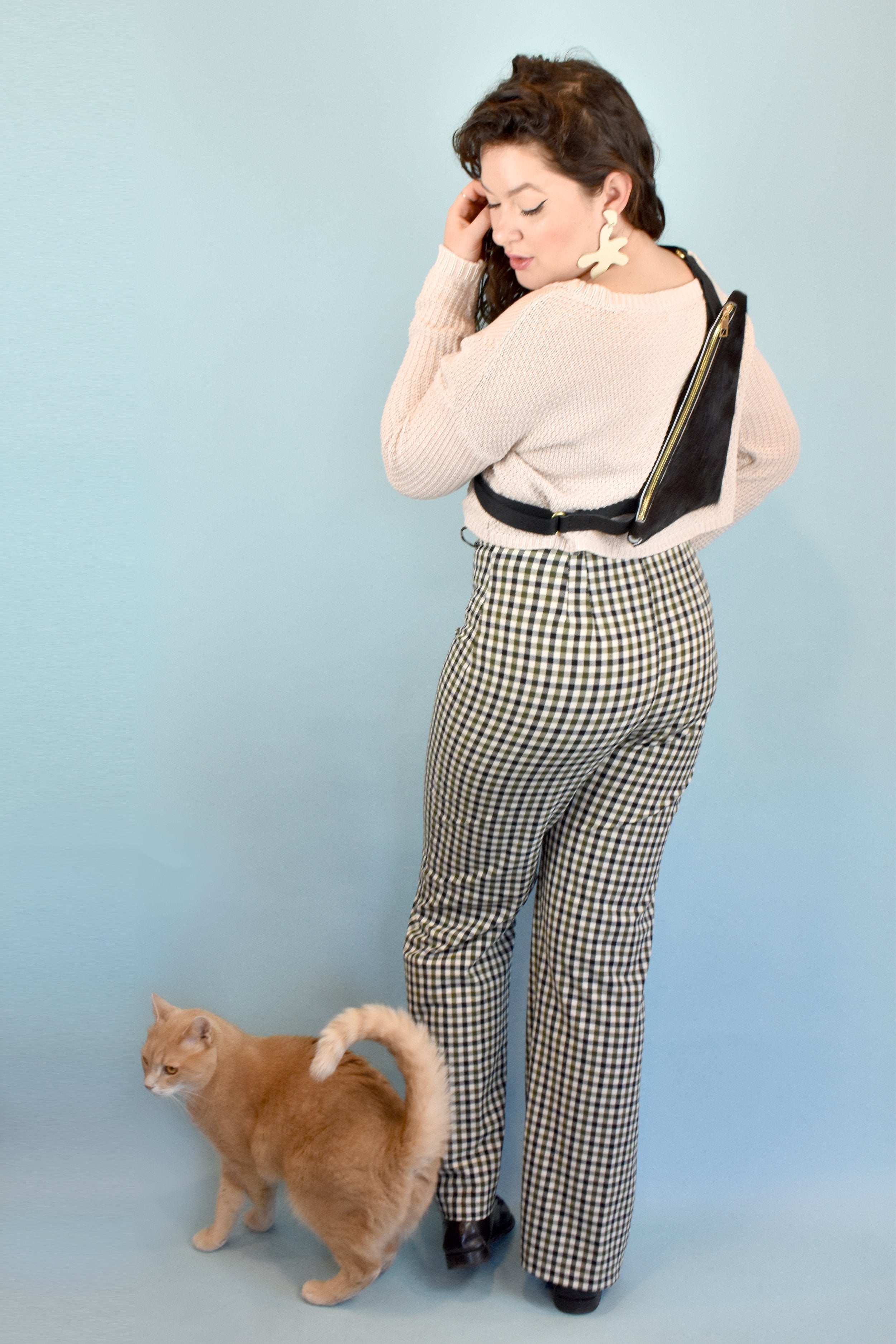 girl with a crossbody style leather bag poses with cat