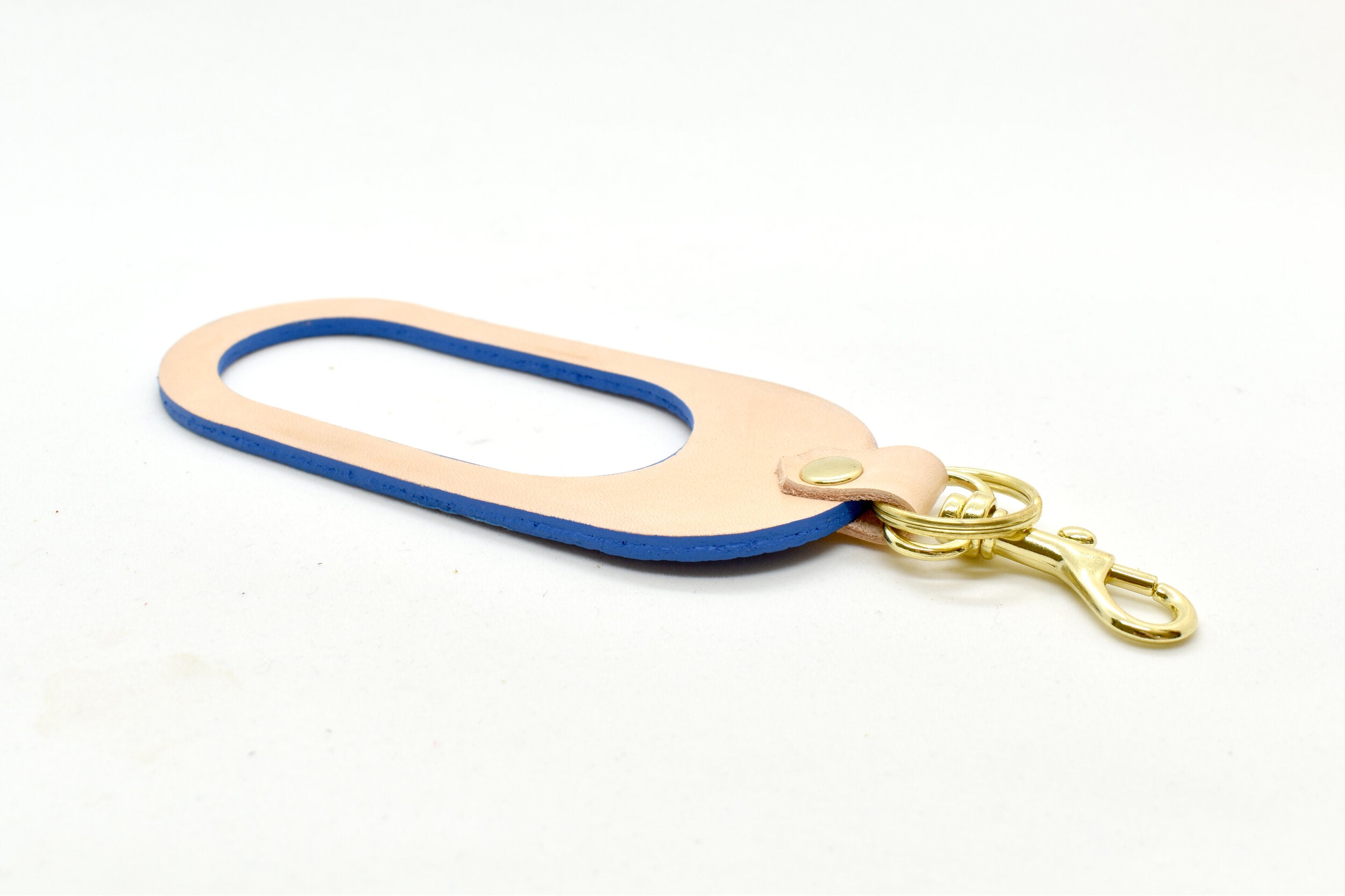 A dual-sided leather multicolor keychain in veg tan leather and saturated Matisse Blue leather