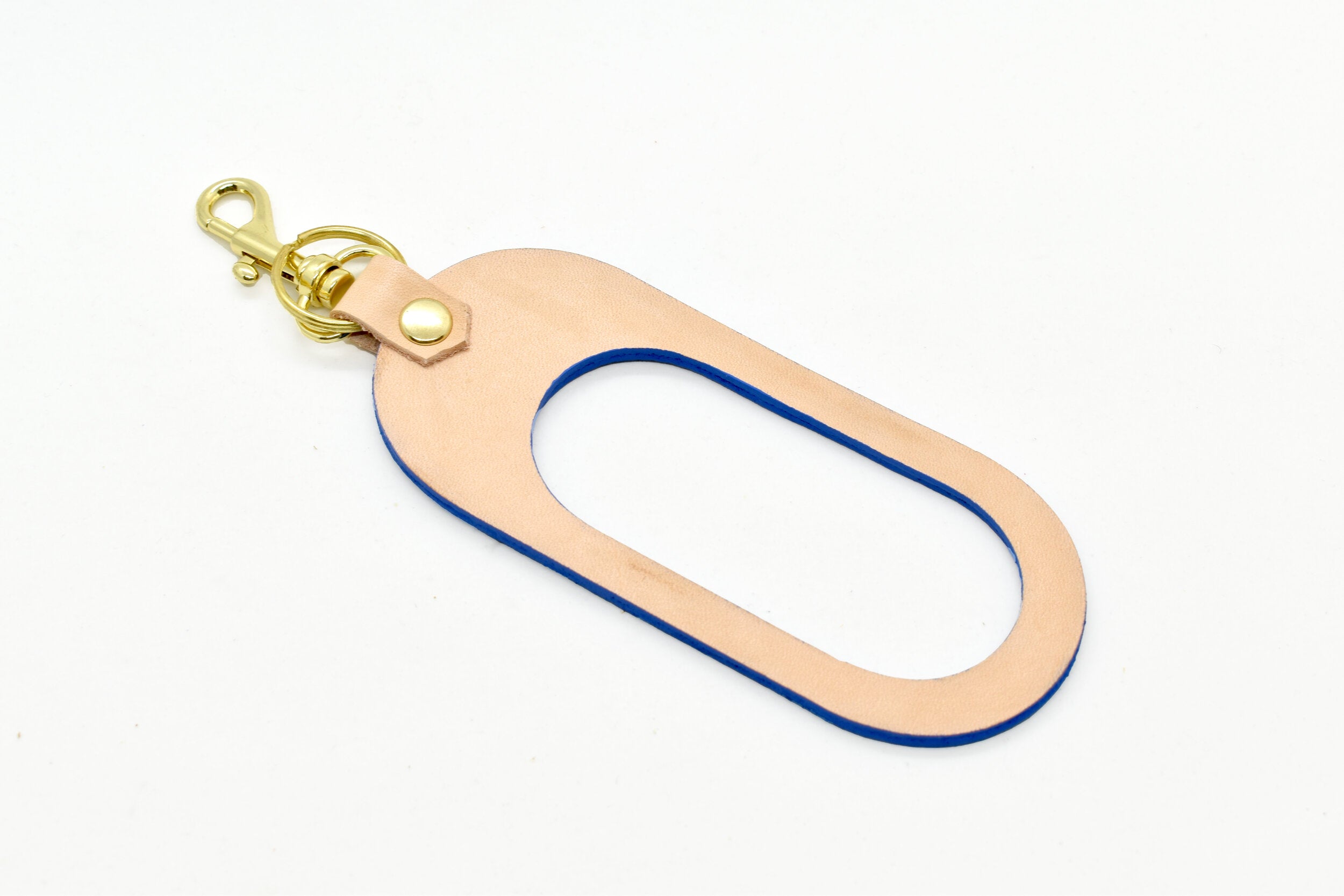 a modern leather keychain with cutout finished with a gold key ring and clasp in vegetable tanned and matisse blue leathers