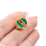 hands holding a pair of geometric half moon stud earrings in emerald gemstone green clay