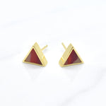 gold triangle stud earring set in ruby gemstone like clay against a white background