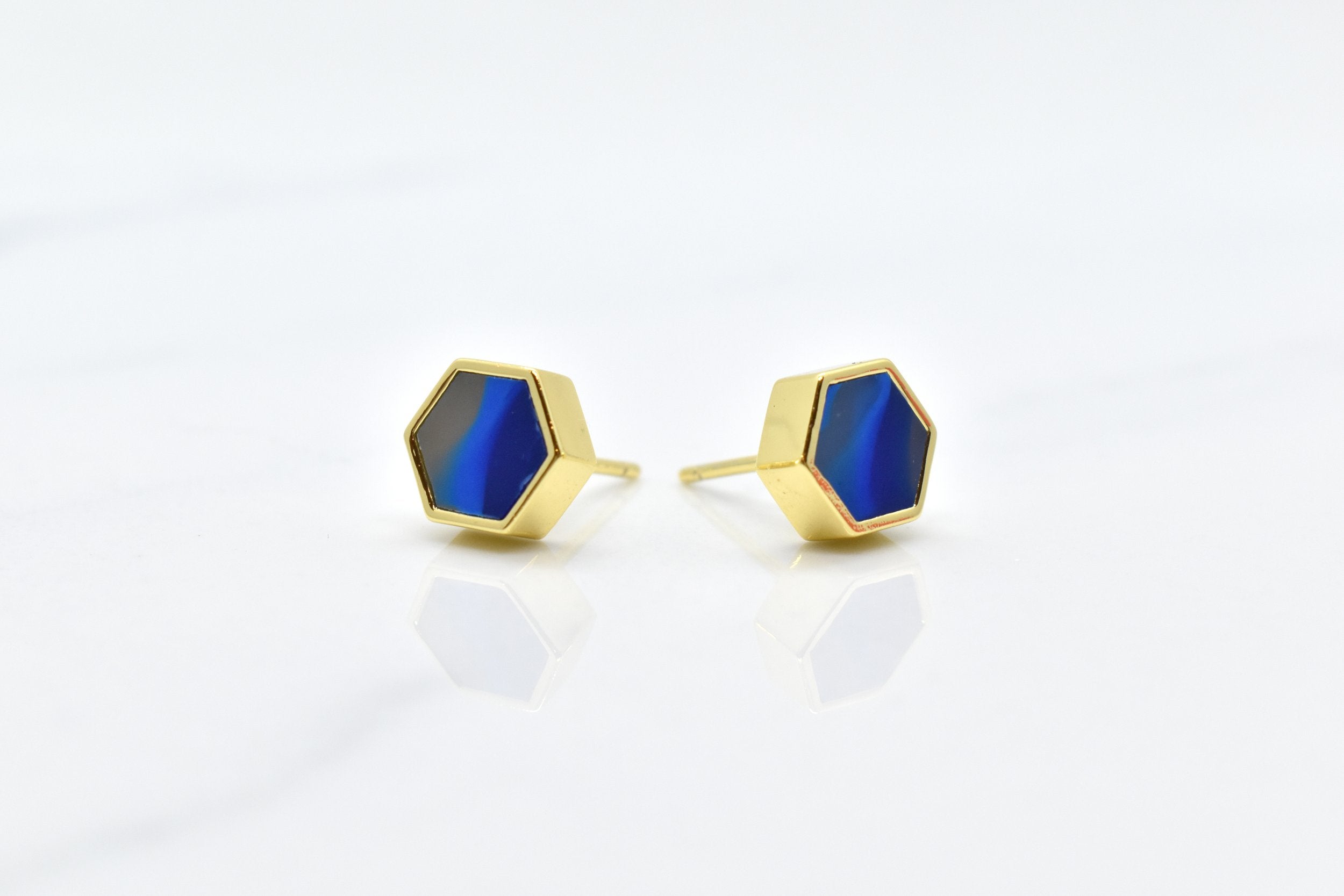 blue and gold hexagon stud earring set with swirling sapphire texture and 14k gold hexagon shape against a white background