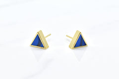gold triangle stud earring set in sapphire gemstone like clay against a white background