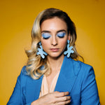 a blonde woman wears starfish shape cutout authentic leather earrings in soft blue.