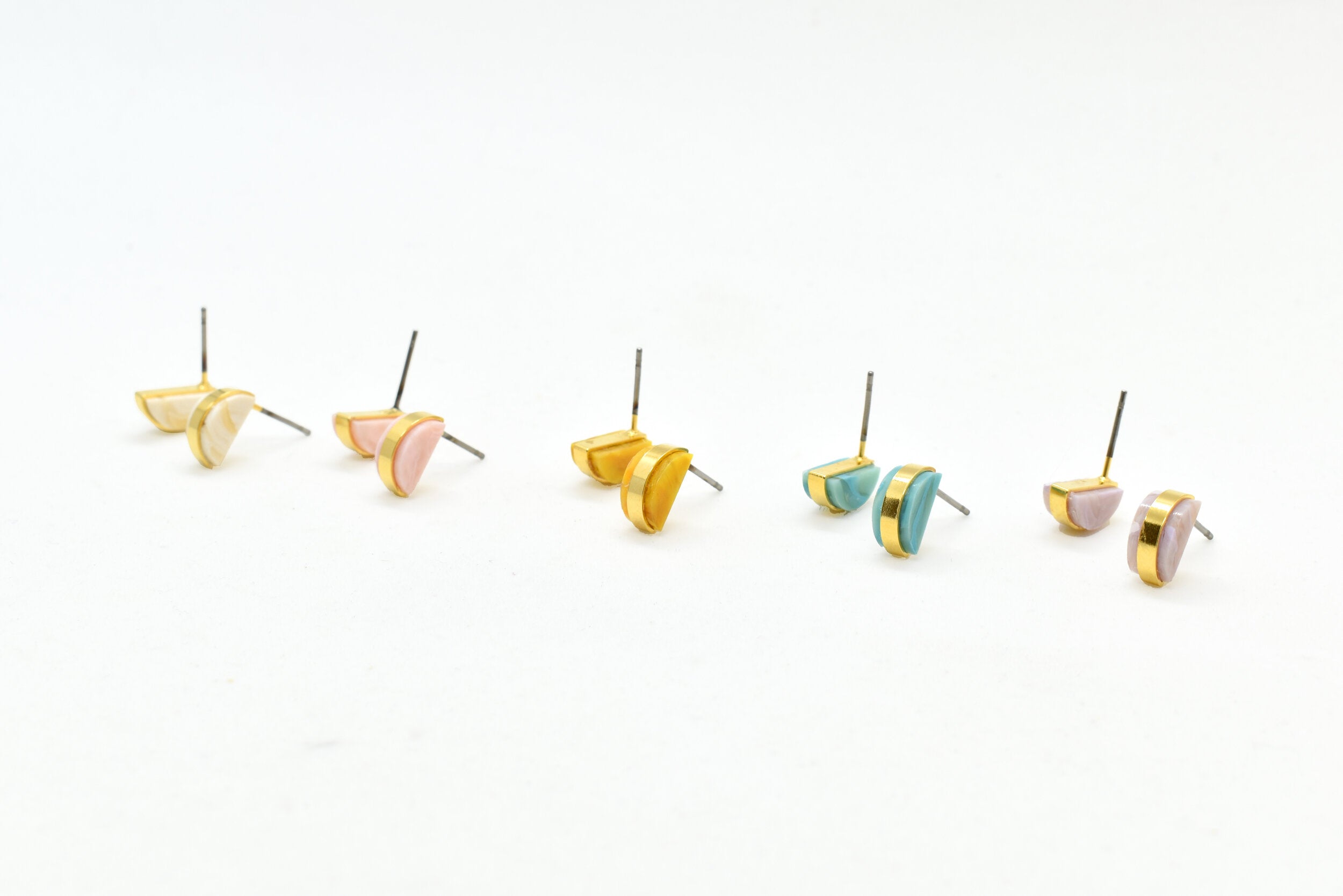 small, architectural gold art deco earrings in crystal, pink, golden, aqua, and lilac.