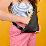 person showing a black sling that can fit an iphone triangle leather bag lightweight hiking sling great for outdoors accessories