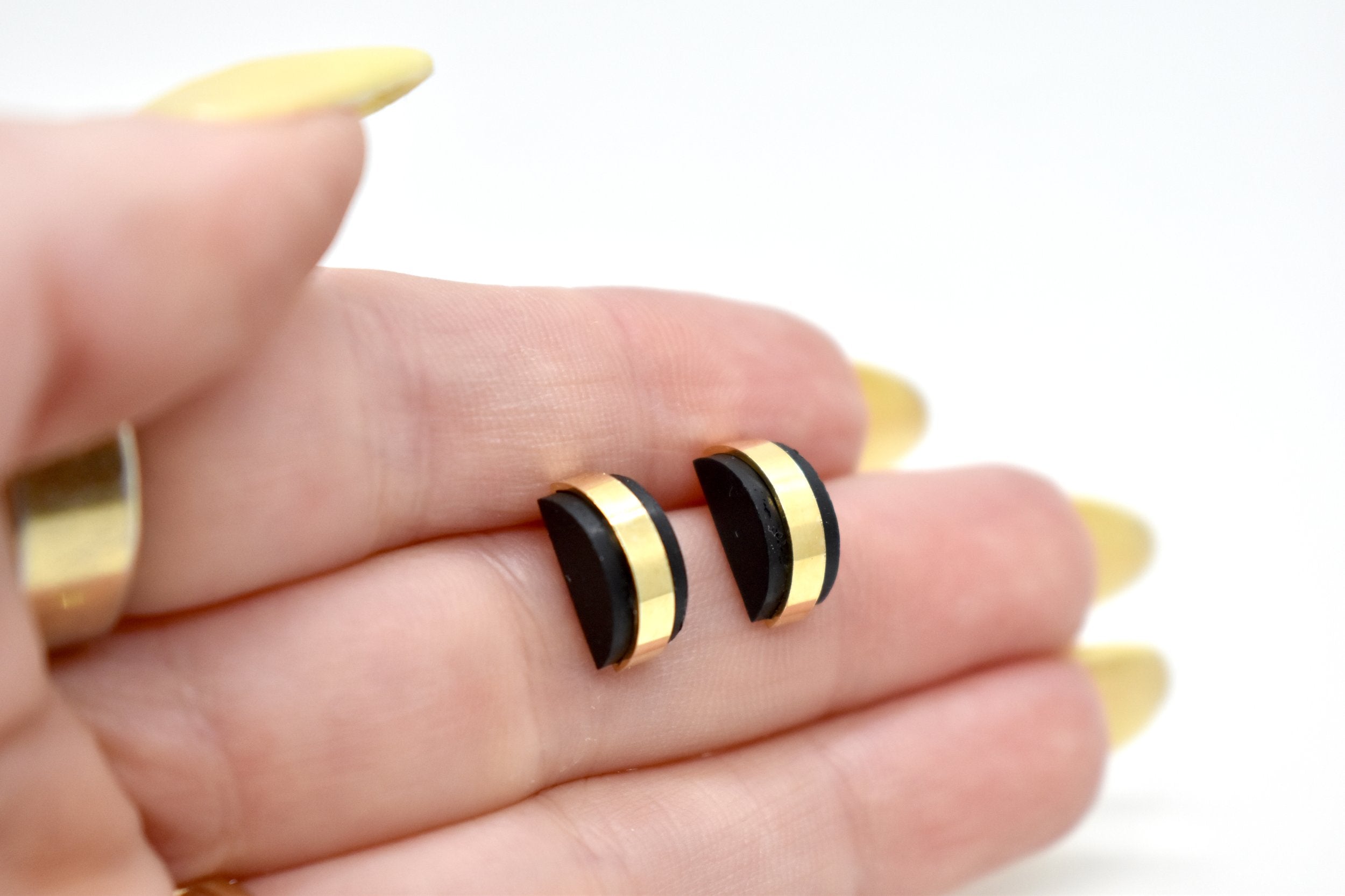 hand holding modern architectural small stud earring set jewelry black clay gemstone