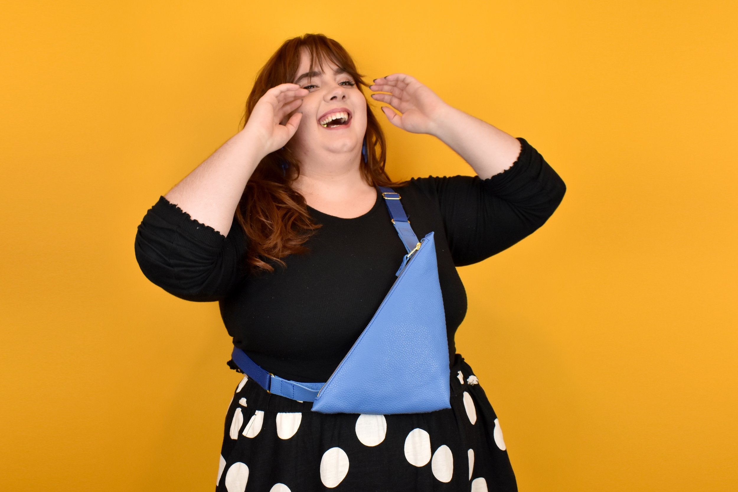 person laughing and wearing a matisse inspired leather sling bag in modern style accessories