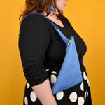 a person shown from the side with a sling bag in matisse aesthetic blue pop of color bag colorful sling for outdoor adventures