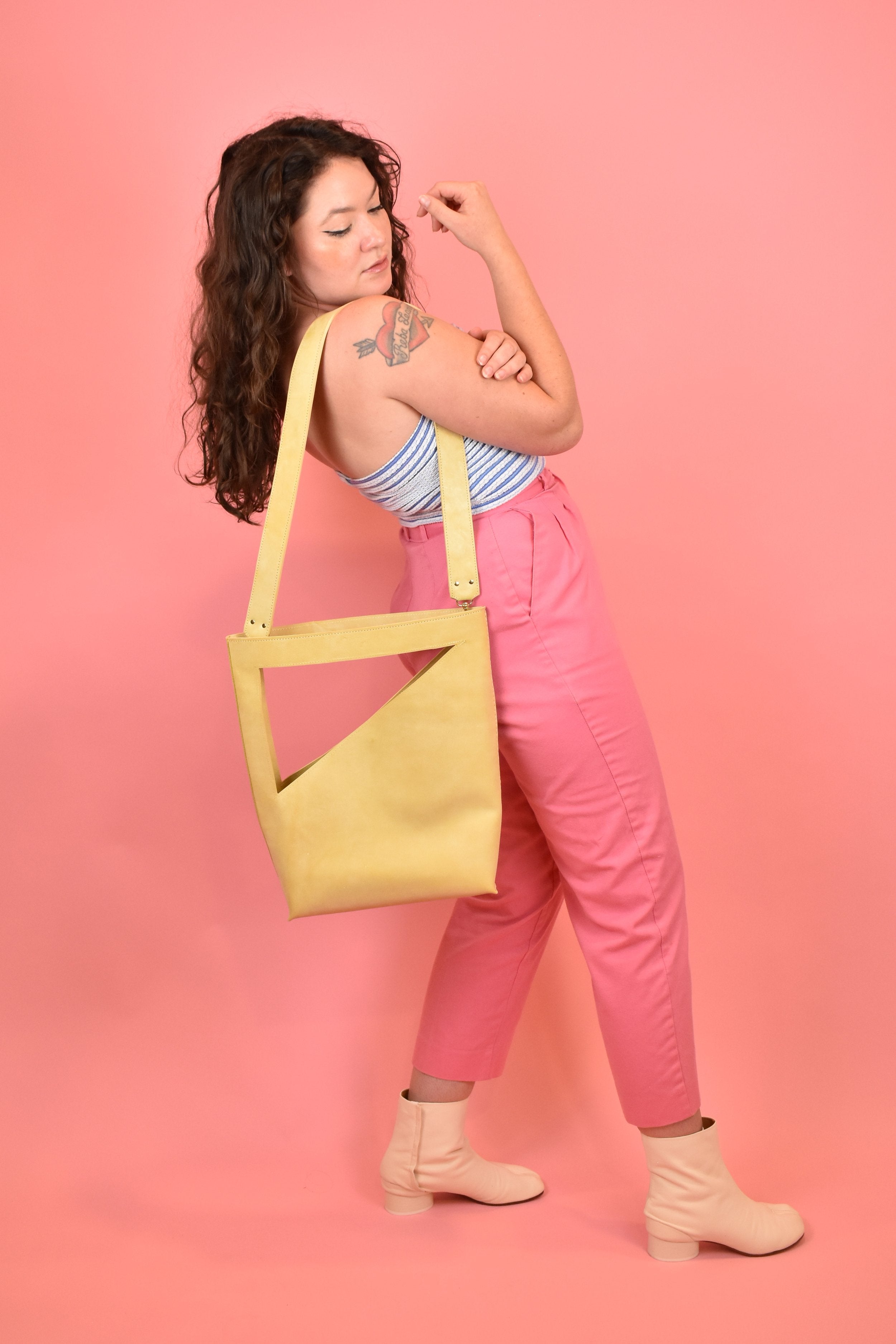 pale yellow crossbody bucket bag hanging off shoulder