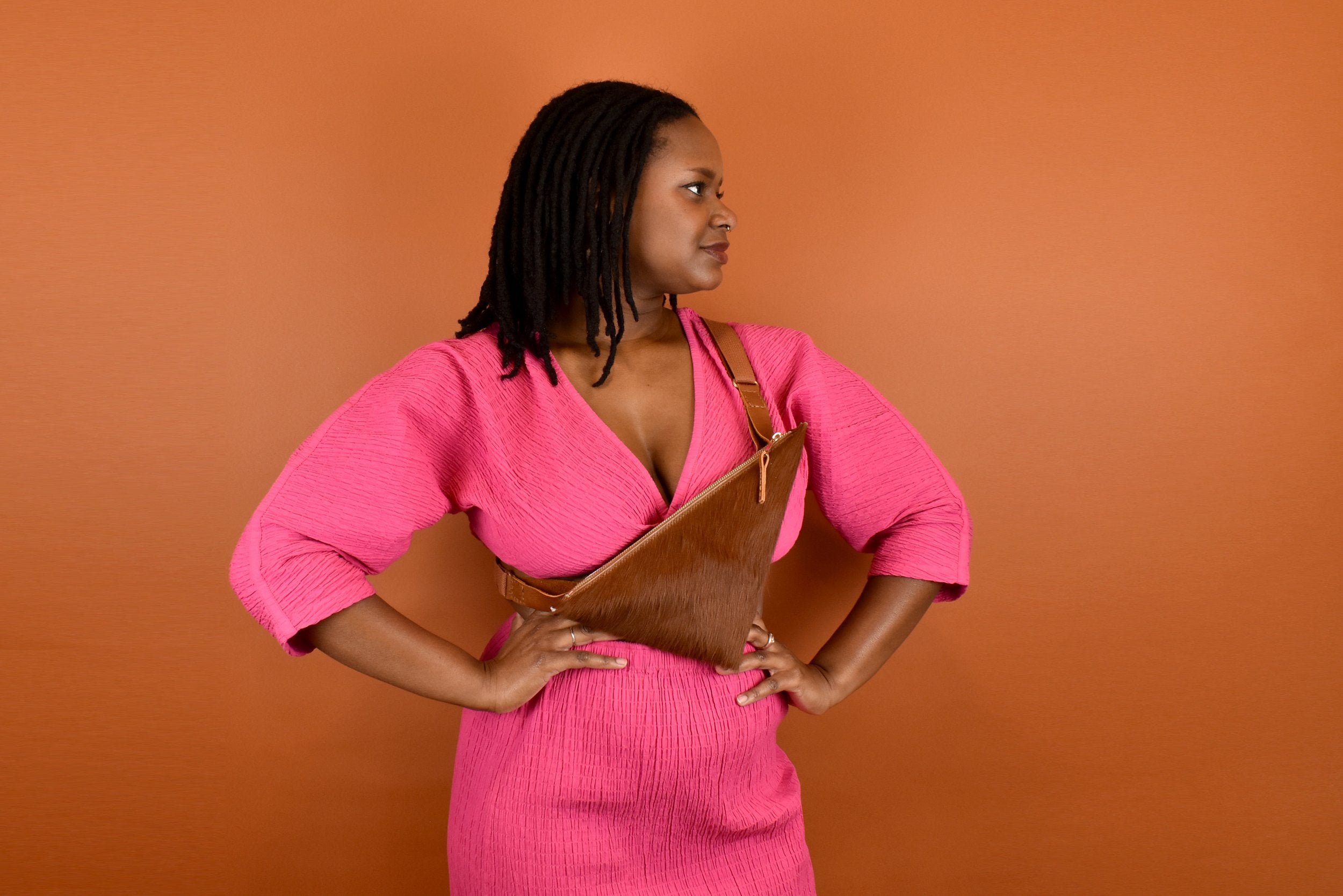 a woman wearing cow print crossbody bag cute maximalist accessory minimal leather bag sling gift for bride bridesmaid gift leather sling with inside pocket on her chest