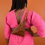 a woman wearing a cow sling bag trendy accessory maximalist leather bag minimal leather sling birthday gift for sister gift for birdesmaids on her back