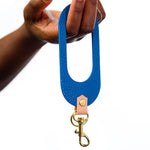 hand holding matisse style blue leather wristlet keychain modern minimal leather accessory