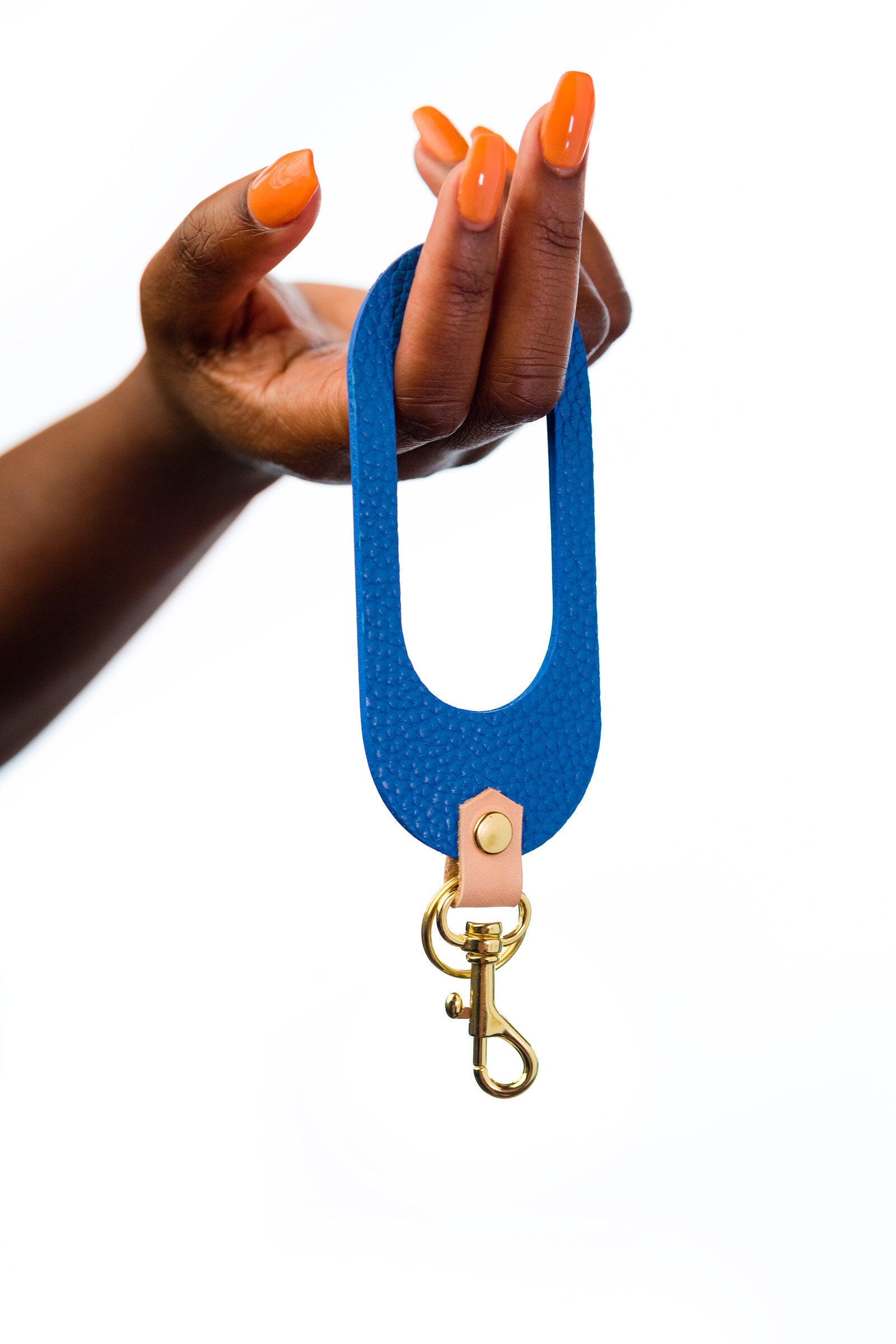 hand holding matisse style blue leather wristlet keychain modern minimal leather accessory