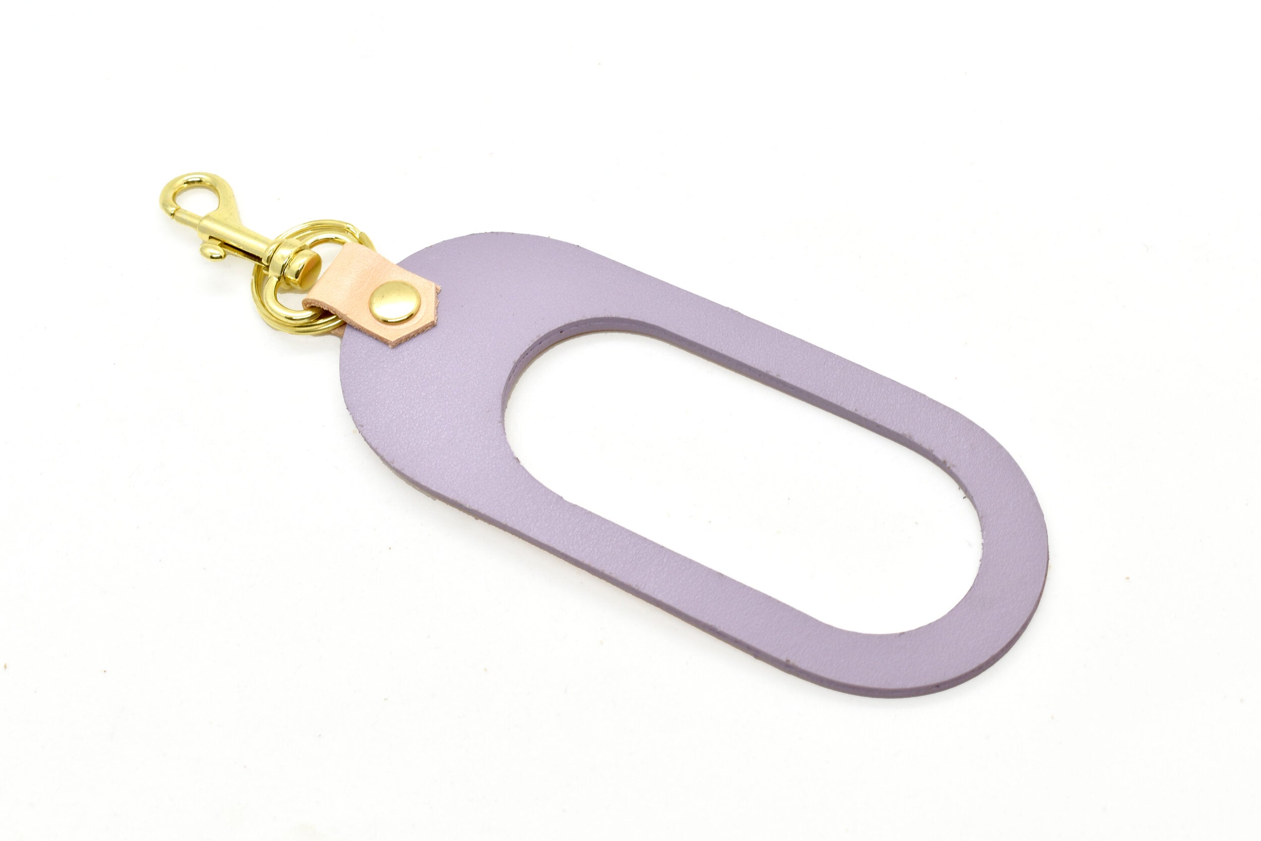 A vegetable tanned rawhide pastel lavender leather keychain with gold clasp hardware