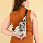 a girl wears a leather sling bag for coachella essentials bag small leather sling bag crossbody cowhide leather purse cowprint gift for bride sling bag with inside pocket on her back