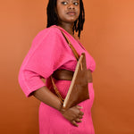 a woman wearing a leather sling bag cowgirl accessory minimal leather purse cowhide minimal leather sling gift for best friend cow favors for bachelorette party over her shoulder