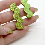 Hand holding Metallic Lime Green Zigzag Statement Earrings, Metallic Leather Matisse Earrings