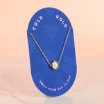 polka dot terrazzo necklaced displayed on blue cold gold branded jewelry card that says smile from ear to ear