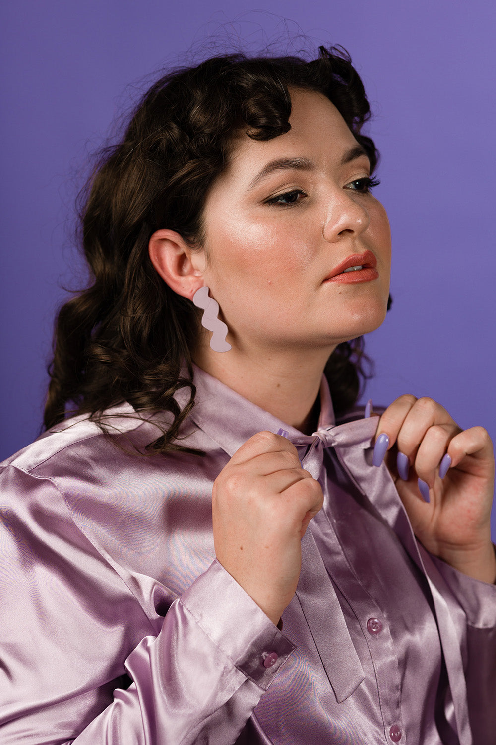 purple lavender zigzag leather stud earrings on dark curly haired model 
