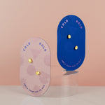 two product cards displaying two pairs of gold plated egg shaped earrings embellished with multicolored CZ tiny gemstones