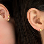 close up of two models wearing 6mm modern gold pearl stud earrings encrusted with micro CZ gemstones