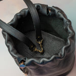 interior of pebbled black leather wristlet bag with adjustable hardware