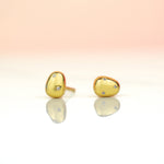 close up of 14k gold plated pearl studs encrusted with crystal gemstones