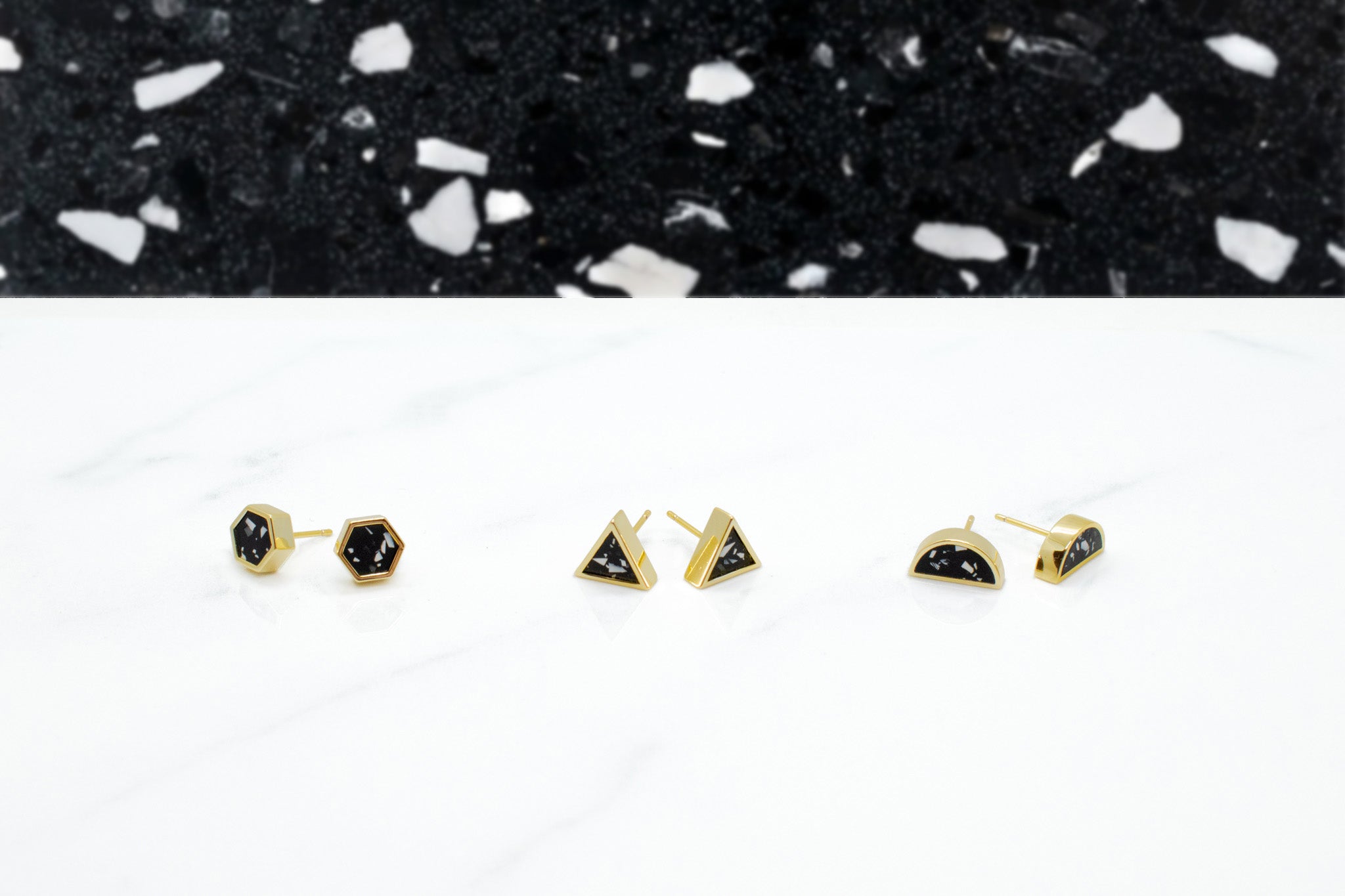 black and white clay terrazzo design gold stud earrings lined up in three different geometric styles: hexagon, triangle, and half moons