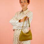 medium sized leather shoulder bag in olive green with detachable strap and gold hardware