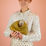 model holding convertible small leather handbag in olive green