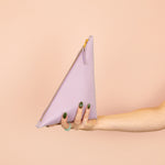 hand holding up pale purple modern leather triangular clutch handbag 