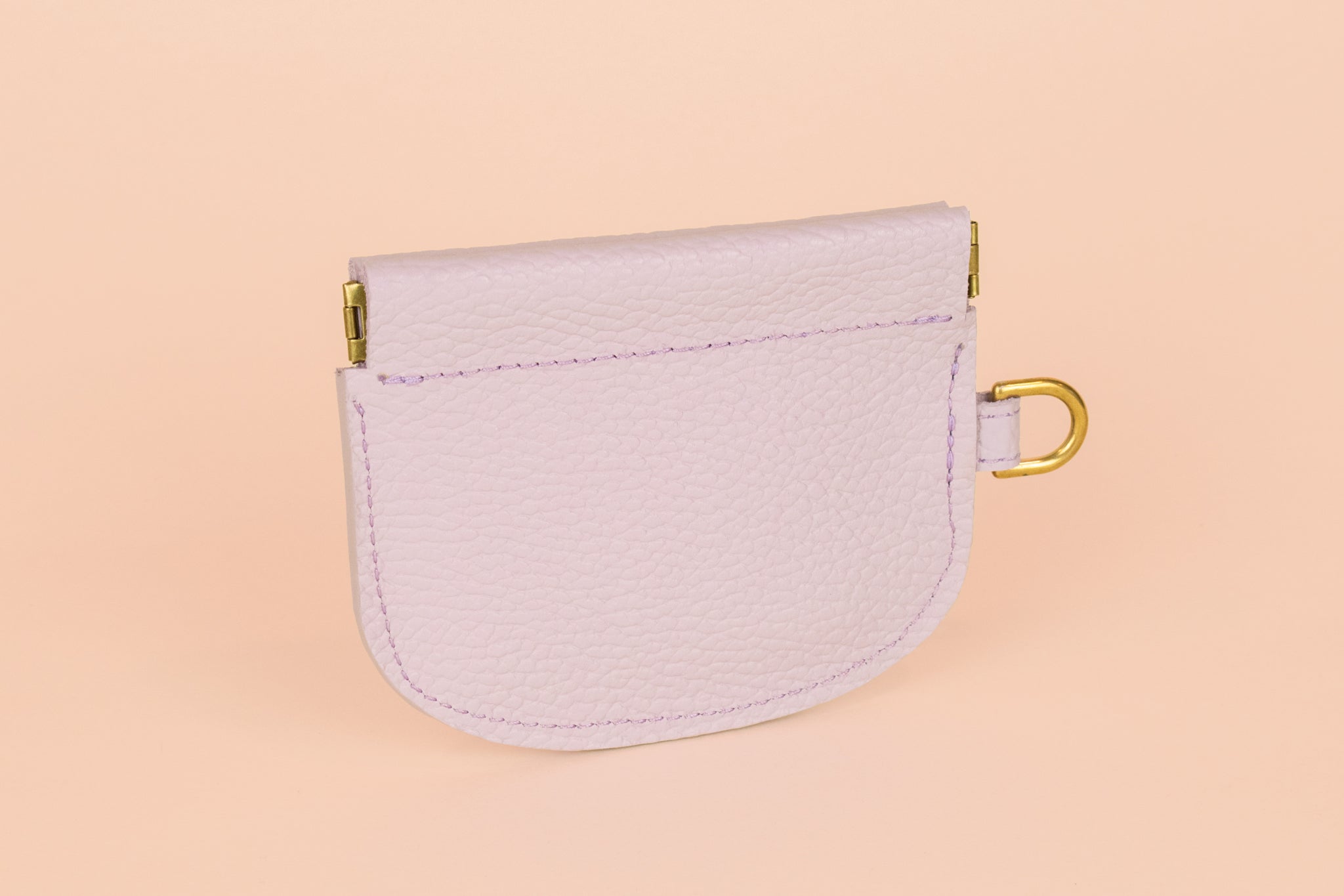 back side of lilac card wallet with gold hardware for attaching keys and snapping open and closed