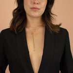 model wearing plunging blazer showcasing gold plated layered lariat chain necklace