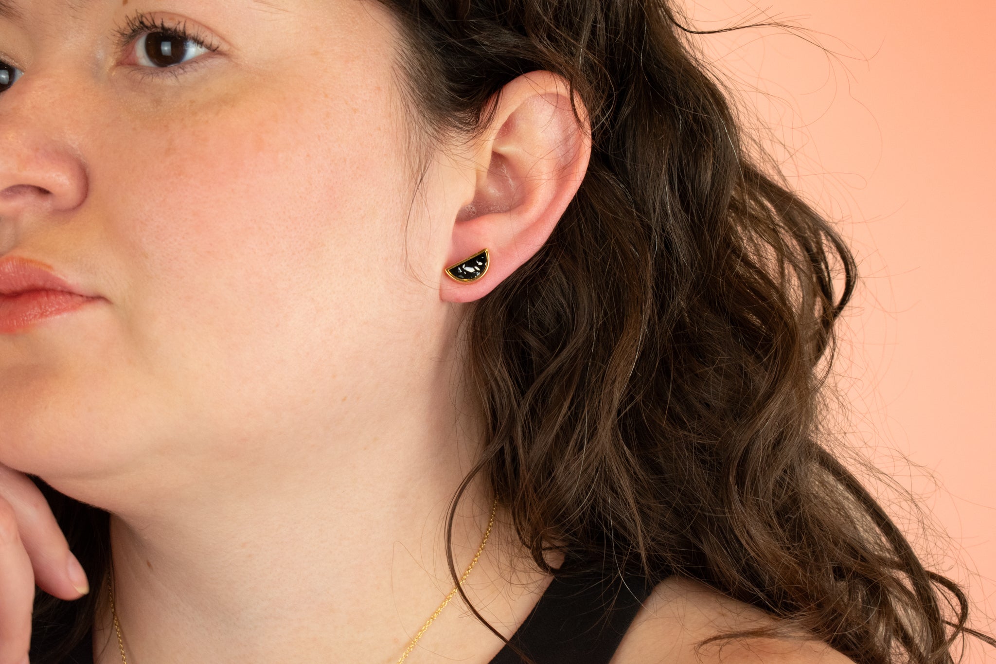 model wearing gold geometric stud earring in black terrazzo