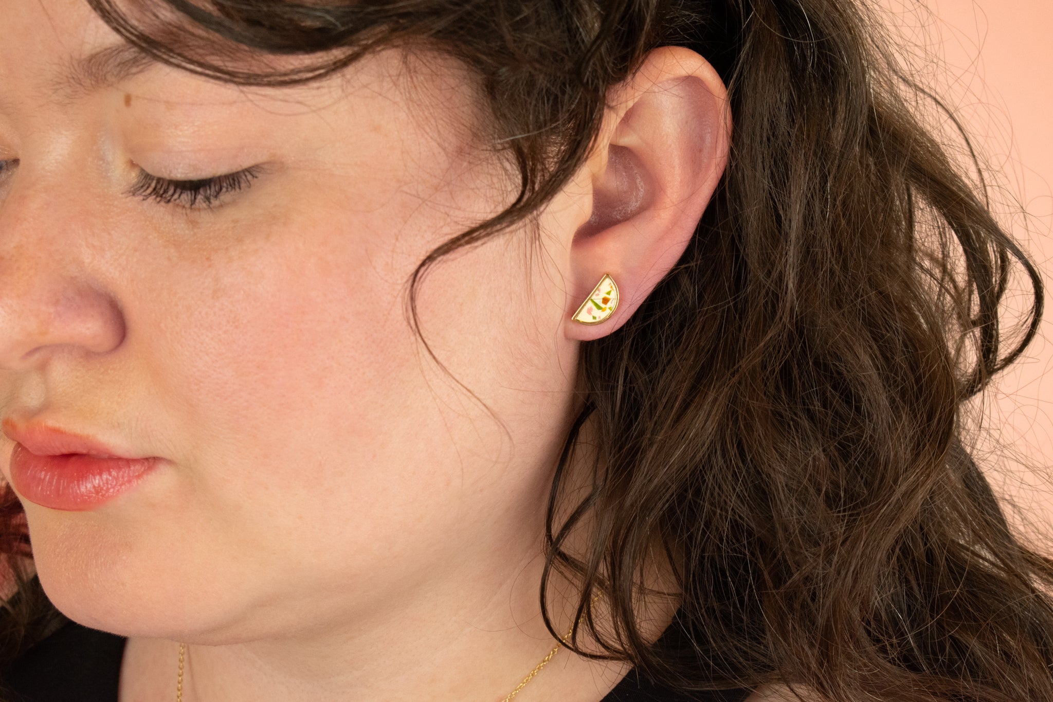 side profile of model wearing a modern gold half moon earring in mosaic style