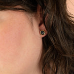 side profile of model wearing modern black and gold hexagon earring in terrazzo style