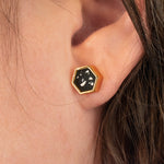 close up of models ear wearing black and white statement earring gold-plated hexagon shape