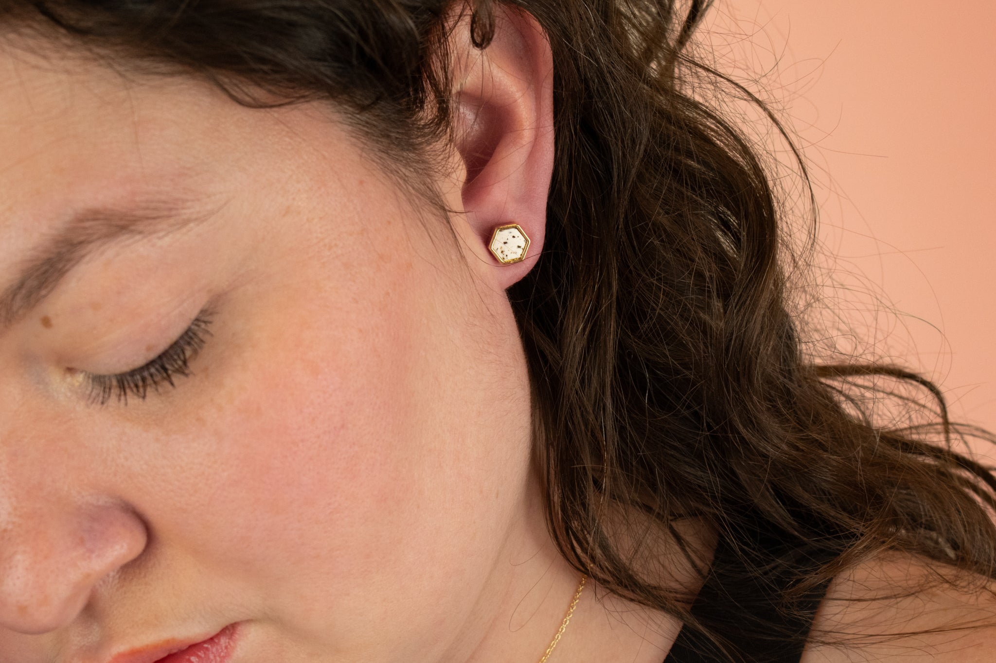 side profile of model wearing gold hexagon earring with polka dot pattern