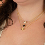 close up shot of model wearing various colorways of gold style terrazzo necklaces