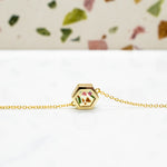 contemporary gold hexagon necklace flecked with chips of stone in terrazz style