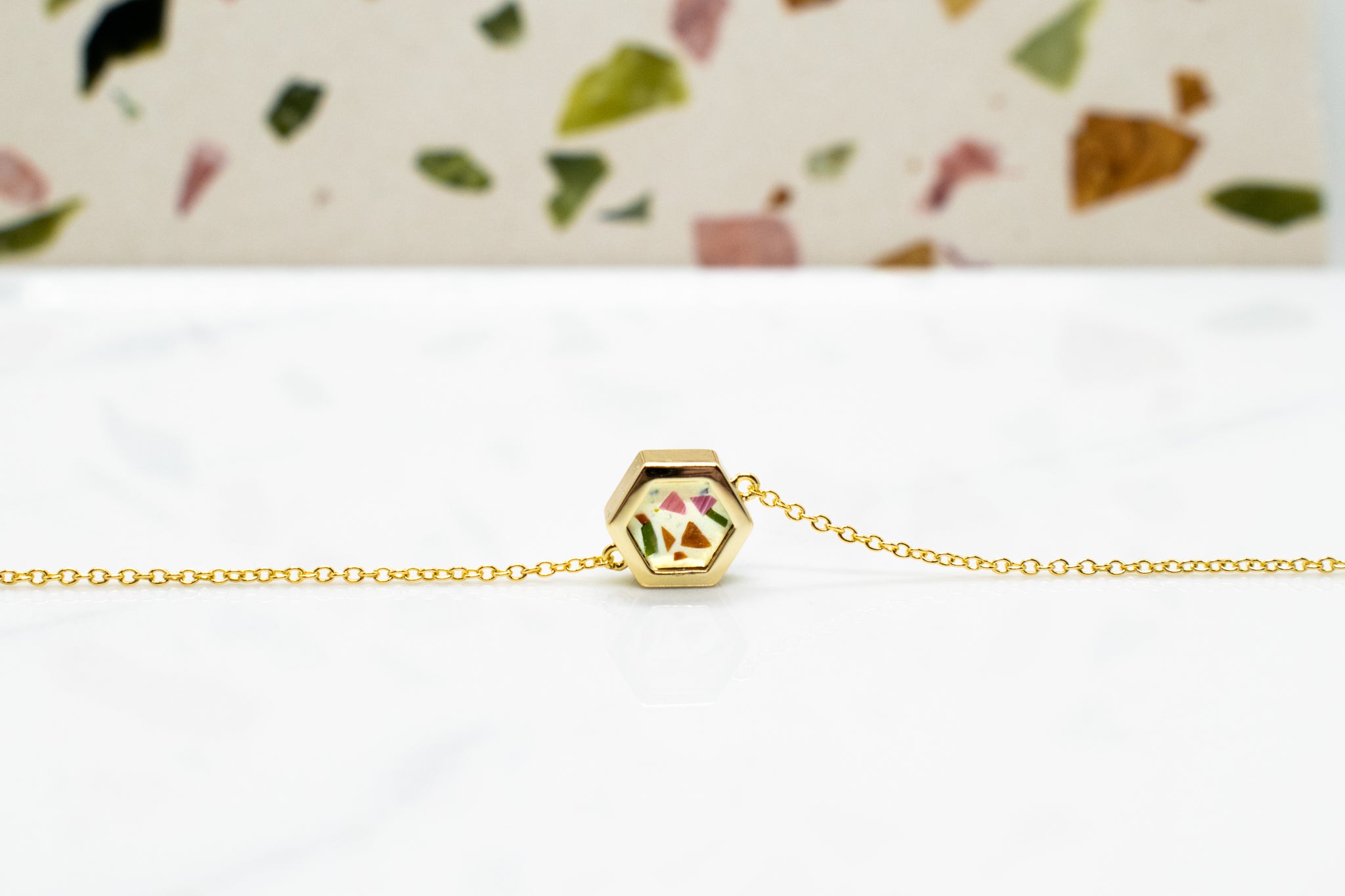 contemporary gold hexagon necklace flecked with chips of stone in terrazz style