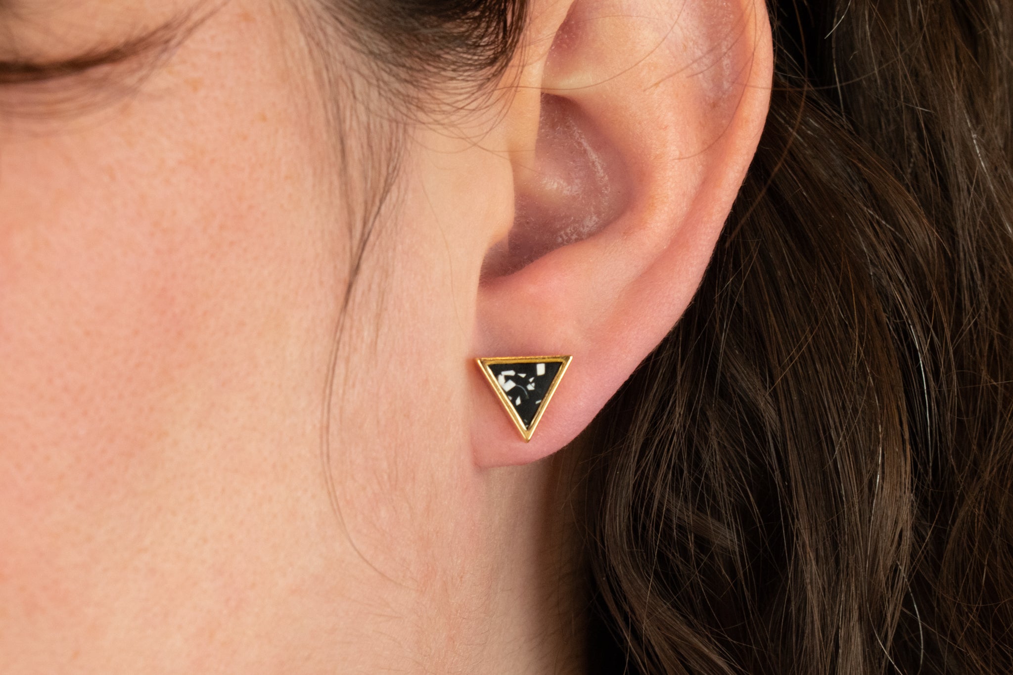 close up of models ear wearing everyday black terrazzo and gold earrings