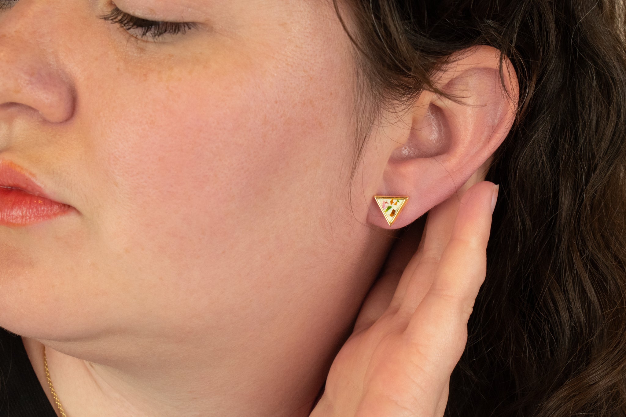 model wears stone inspired geometric stud earrings in terrazo and gold