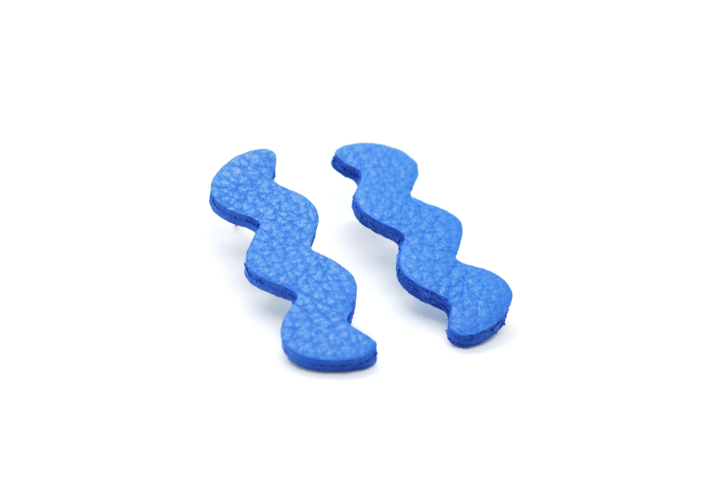 memphis style modern art ear rings in textured blue leather.
