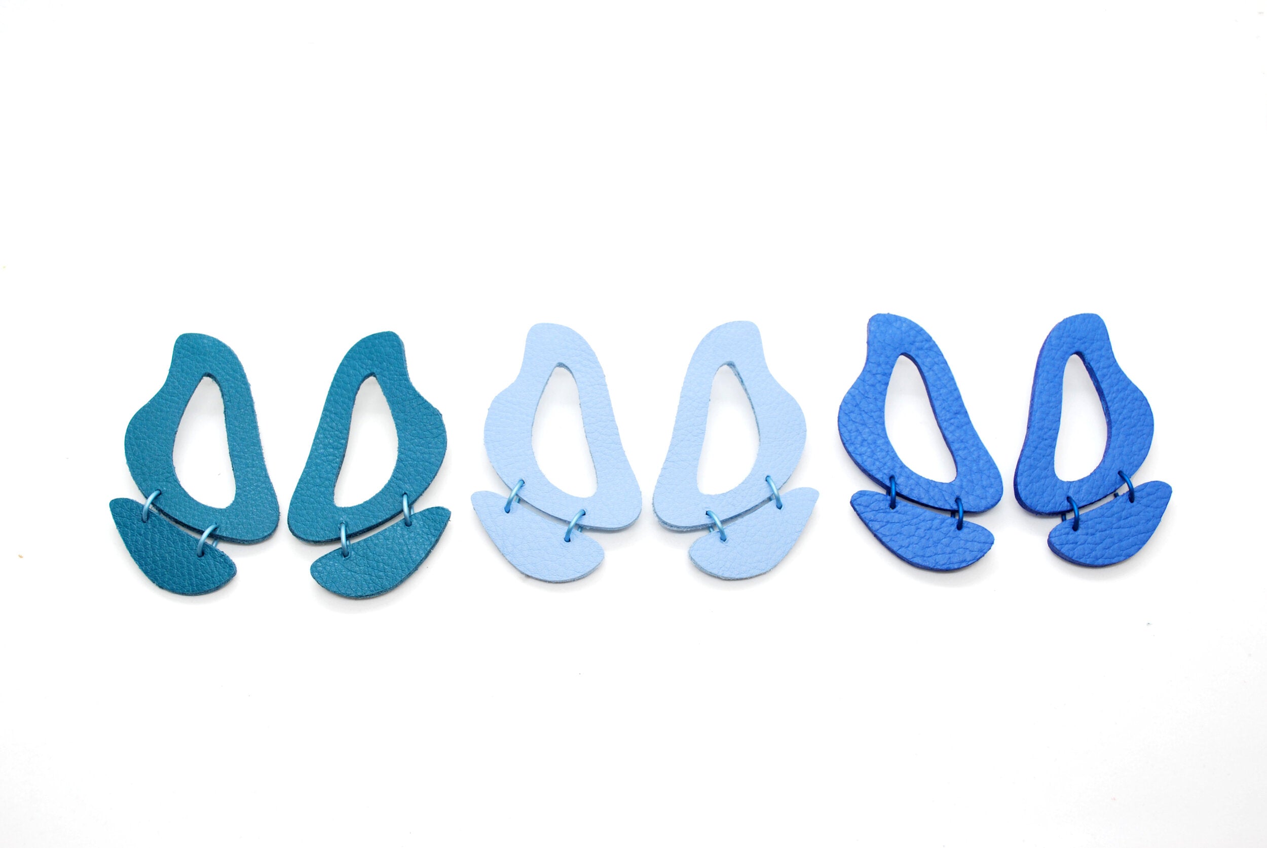 round cutout leather dangly earrings in turquoise, periwinkle, and matisse blue.