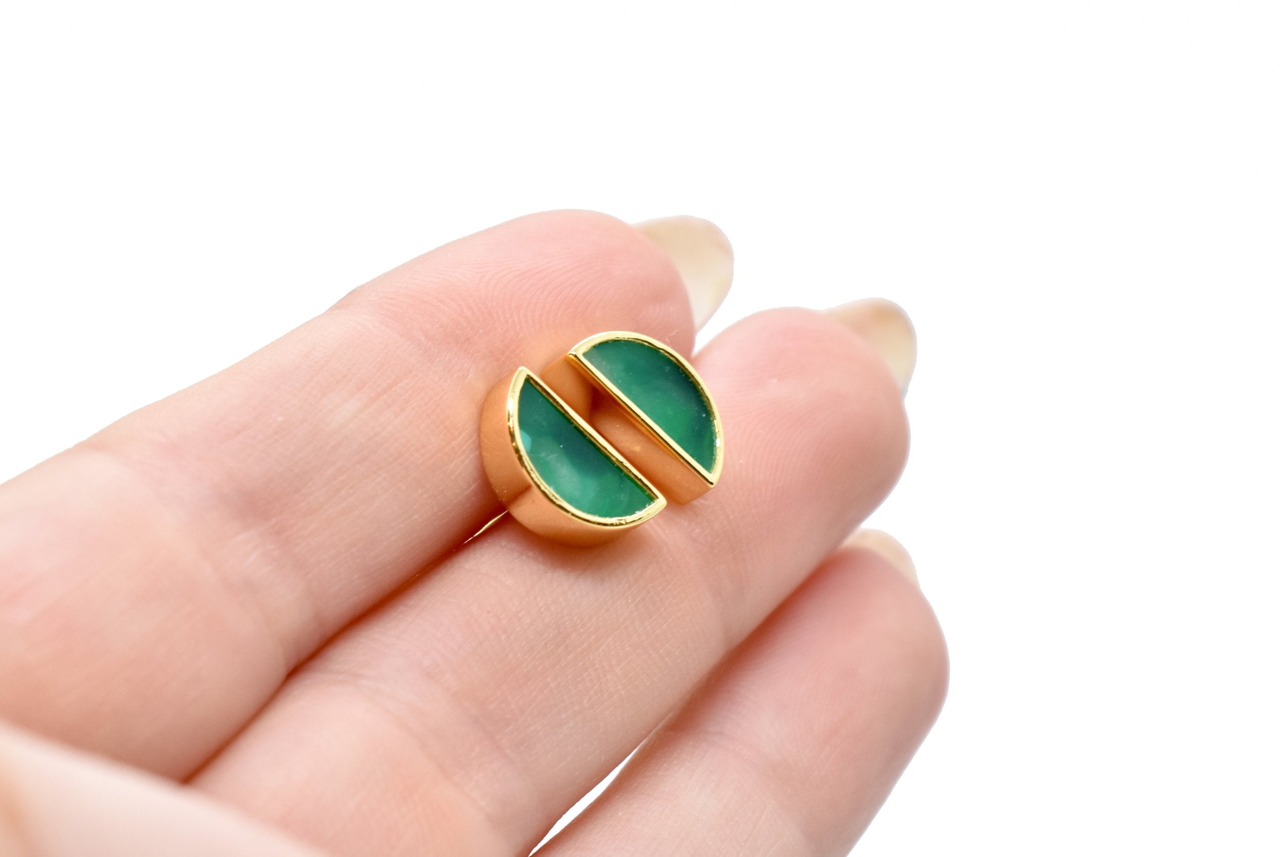 hands holding a pair of geometric half moon stud earrings in emerald gemstone green clay